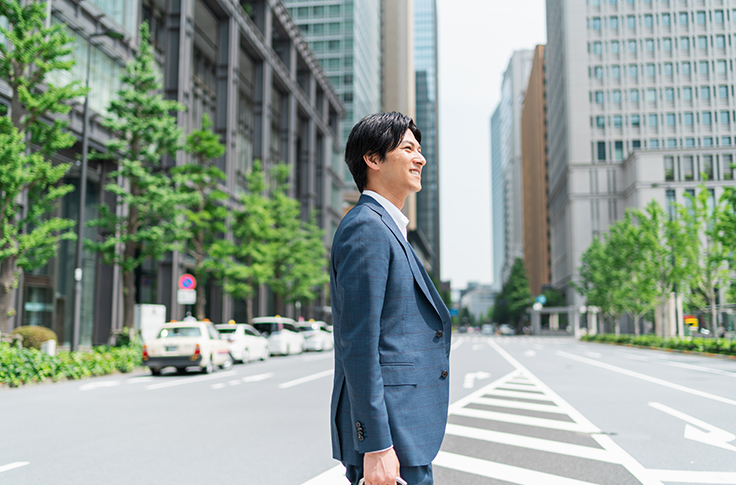 30代のビジネスパーソンが笑顔を浮かべている写真